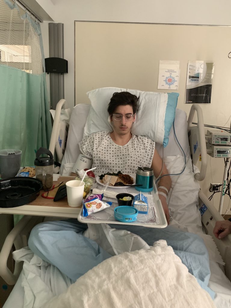 Young man sitting up in hospital bed