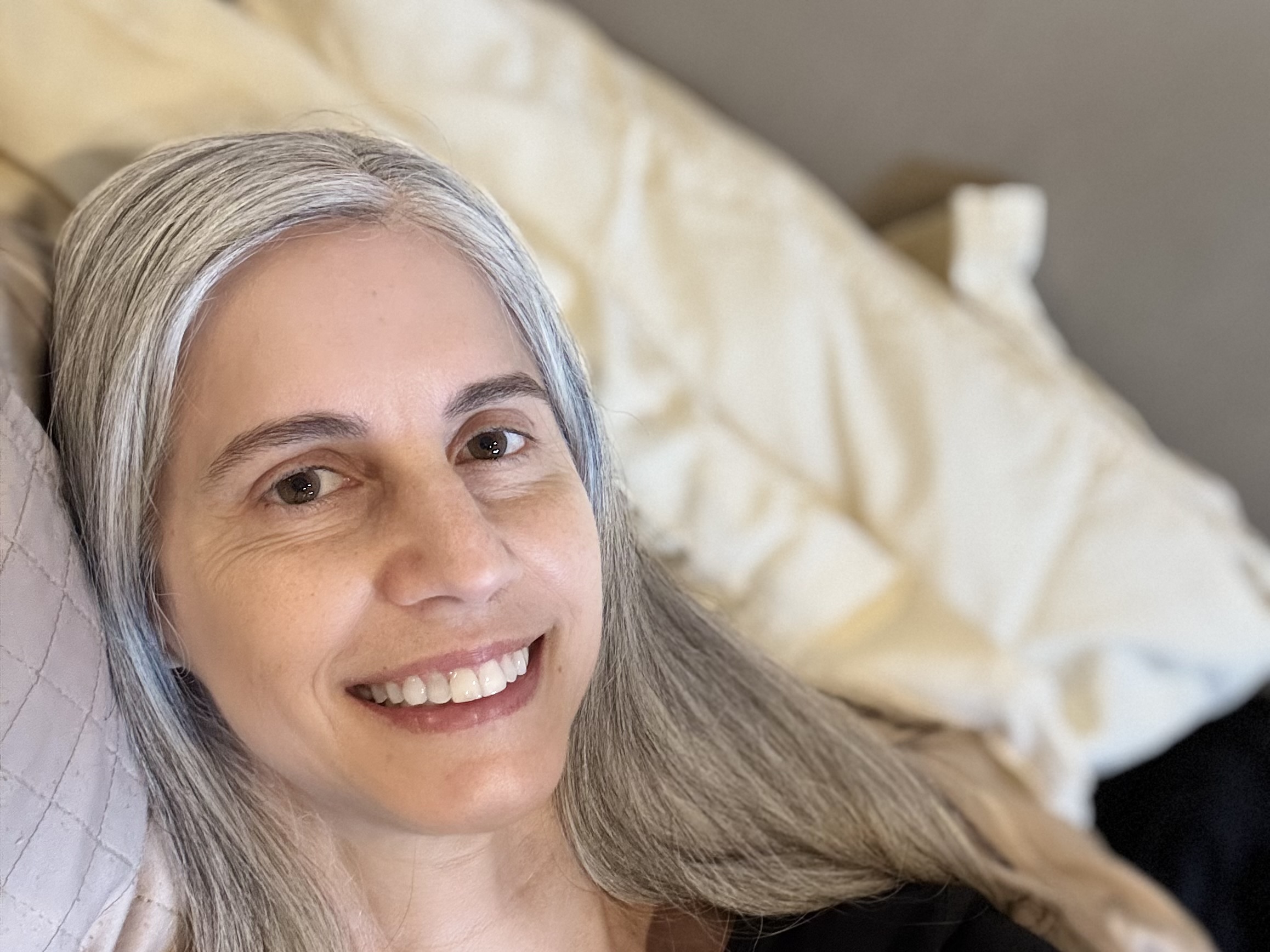 woman with gray hair lying on pillow